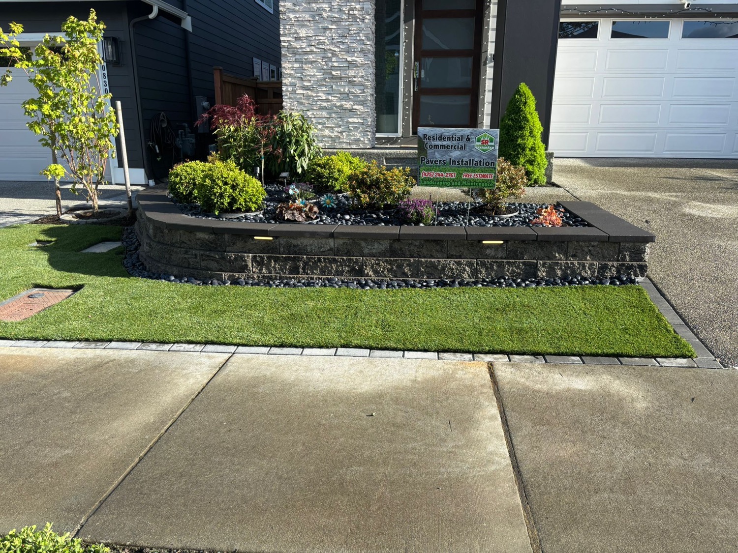 Finished front bed with turf, flowers, pavers, and SR Landscaping project sign
